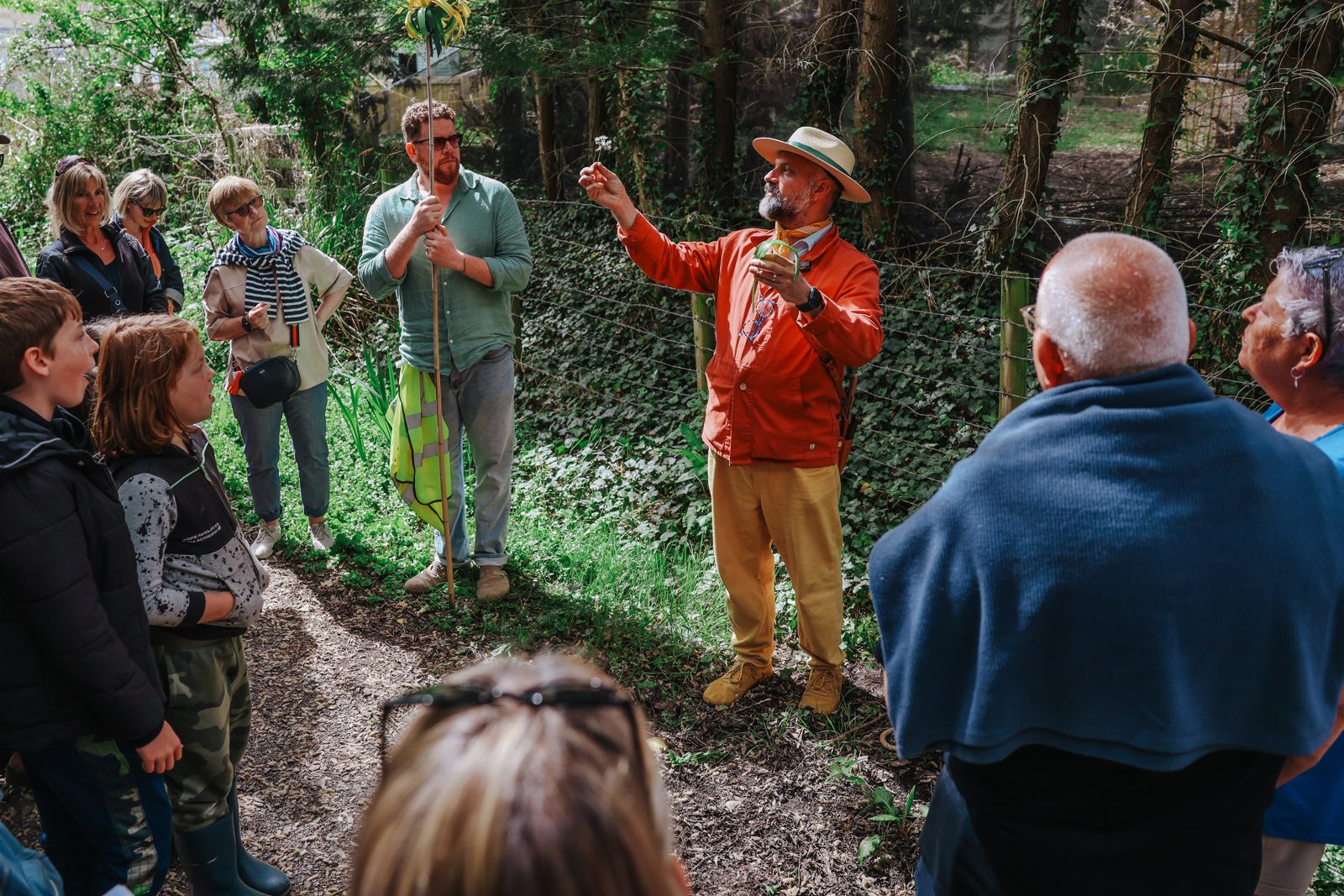 Stories of the wayside: the group pauses to identify a hedgerow plant.
